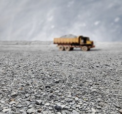 A granite quarry mine with a tipper lorry transporting stones in the horizon.