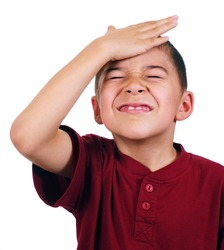 Eight-year-old boy slaps his forehead in an oh-no moment, disappointed, isolated on white background