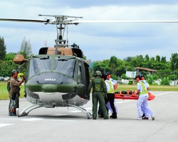 KORAT, THAILAND - SEP 15 : Military Rescue Team(white) pulling cart with wounded person to helicopter in Search and Rescue Exercise(SAREX) on September 15, 2012 in Nakhonratchasima,Thailand