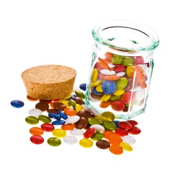 sweet sugar spreading pastry scattered from an open glass jar, isolated on white background