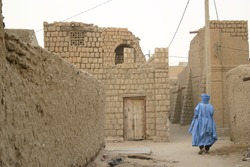 A Tuareg nomad of the Berber people wanders the muddy back streets of Timbuktu, Mali