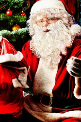 Santa Claus sitting with presents over Christmas background.