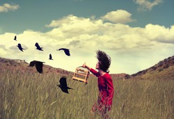 a girl walking through a field with a flock of ravens or crows toned with a retro vintage instagram filter effect action app
