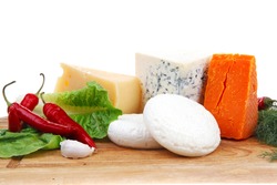 various types of cheese on wooden board with hot peppers and dill isolated over white background