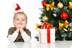 Happy little girl smiling with gift box near the Christmas tree. Christmas concept.