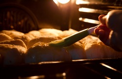Preparing baking into the oven. Pies cover with a mixture of egg.