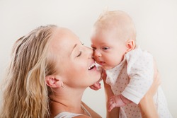 Happy young mother with her baby on white background. Happy family with newborn.