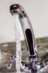 Stream of cold water flows from the metal tap