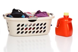 Laundry basket with clean, folded clothes and a bottle of Laundry Detergent isolated on white.
