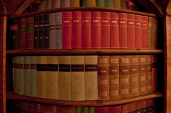 Various old books on the shelf, low light environment.