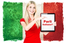 Parli italiano? italian language learning concept. young woman with italian national flag on the background holding tablet pc.