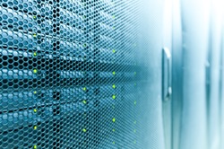 Abstract of modern high tech internet data center room with rows of racks with network and server hardware.