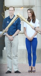 Prince William and Catherine, Duchess of Cambridge welcome the olympic torch to Buckingham Palace, London, UK. July 26, 2012.