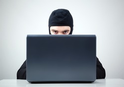 Hacker stealing information from a computer at the desk