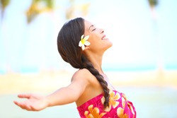 Freedom beach woman smiling happy and serene with arms outstretched in free pose. Beautiful spiritual elated happiness concept image with multicultural Asian / Caucasian female model.