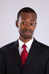Handsome black businessman in suit and red tie with a white shirt looking at the camera with a confidant smile