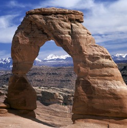 Delicate Arch in Arches National Park, Utah, U.S.A.At the background mountains covered with snow