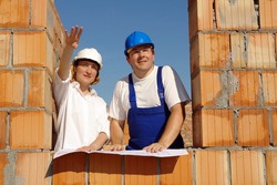 Female investor showing the site manager her house concept standing in brick wall window opening