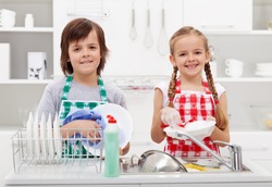 Happy kids helping in the kitchen doing the dishes