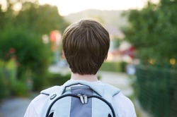 Teen wearing a school bag heading to school.