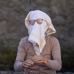 AURILLAC, FRANCE - AUGUST 21:an old woman wears a dish towel on the face as part of the Aurillac International Street Theater Festival, Company L'arbre a vache ,on august 21, 2013, in Aurillac,France.