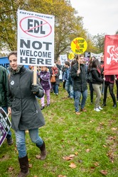 EXETER - NOVEMBER 16: A lady holds up a 'EDL Not Welcome Here', with a stop the Nazis sign behind her during the Exeter Together march and diversity festival on November 16, 2013 in Exeter, Devon, UK