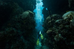 BLUE HOLE, BELIZE - NOVEMBER 26: Scuba diver swims through tunnel on November 26, 2013 in Blue Hole, Caribbean Sea, Belize