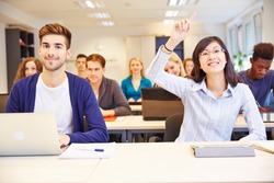 Asian student raising her hand in a university classroom