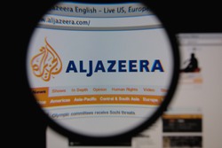 LISBON - JANUARY 25, 2014: Photo of Aljazeera homepage on a monitor screen through a magnifying glass.
