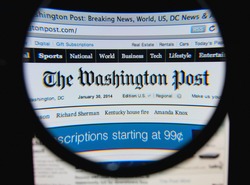 LISBON, PORTUGAL - FEBRUARY 8, 2014: Photo of The Washington Post homepage on a monitor screen through a magnifying glass.