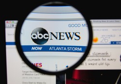 LISBON, PORTUGAL - FEBRUARY 8, 2014: Photo of ABC News homepage on a monitor screen through a magnifying glass.