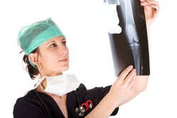 Young attractive Caucasian female health care worker examining an x-ray of a human knee. Isolated on white background