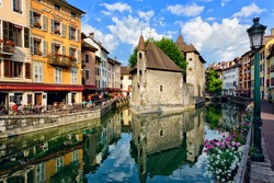 ANNECY, FRANCE - JUNE 22: People drink coffee near the River Thiou in Old Town, encircling the medieval palace perched mid-river - the Palais de l'Isle on June 22, 2014 in Annecy, France.