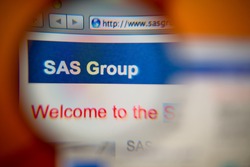 LISBON, PORTUGAL - AUGUST 27, 2014: Photo of the SAS Group homepage on a monitor screen through a magnifying glass.