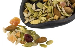 trail mix with pumpkin, sunflowers seeds, almonds, dried papaya, cranberries, raisins and apples on a rustic wooden scoop isolated on white