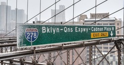 BROOKLYN, NEW YORK - FEBRUARY 15, 2014: Brooklyn Queens Expressway (I278) Exit Sign on the Brooklyn Bridge during a heavy snowstorm.
