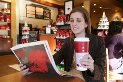 A business woman taking a coffee break and reading the newspaper