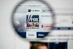 LISBON, PORTUGAL - NOVEMBER 17, 2014: Photo of Fox News homepage on a monitor screen through a magnifying glass.