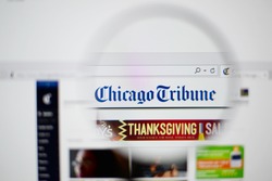 LISBON, PORTUGAL - NOVEMBER 30, 2014: Photo of The Chicago Tribune homepage on a monitor screen through a magnifying glass.