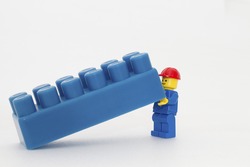 Orvieto, Italy - December 10th 2014: Lego mini figure workman at work on white background . Lego is a popular line of construction toys manufactured by the Lego Group