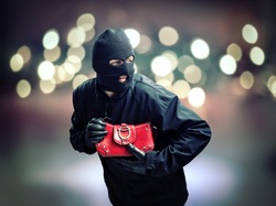 Thief stealing a womans handbag in a city street concept for crime, pickpocketing and security