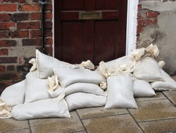 Sandbags stacked in front of door acting as a flood barrier. York, North Yorkshire, UK
