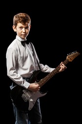 The red-haired boy in a white shirt with an electric guitar on a black background