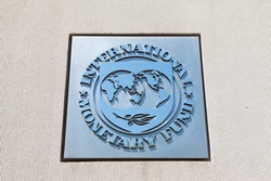 WASHINGTON, DC - MAY 4: Plaque outside the International Monetary Fund (IMF) reflects the blue sky in Washington, DC on May 4, 2015. The IMF, created in 1945, is an organization of 188 countries.