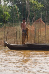 KOMPONG KLEANG, CAMBODIA - FEB 12, 2015 - Young man with fishing net, Kompong Kleang floating fishing village, Cambodia