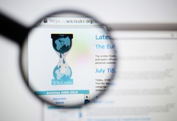 LISBON, PORTUGAL - June 6, 2015. Photo of WikiLeaks homepage on a monitor screen through a magnifying glass.