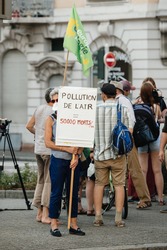 STRASBOURG, FRANCE - AUG 6, 2015: People wearing air masks protesting against air pollution in Strasbourg, Alsace, France - old woman holding placard: pollution kills 50000 yearly