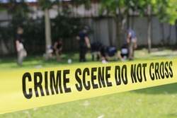 crime scene do not cross tape and blurred law enforcement and forensic background