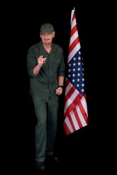 Attractive bearded middle aged man, soldier, saluting American flag, studio shot, black background.