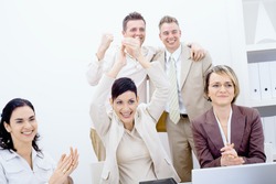 Group of five happy business people smiling and clapping, celebrating business success.